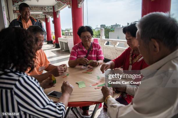 People play a traditional game at a pilgrims rest house near Xingang Fengtian Temple where a statue of Mazu is being displayed before continuing the...