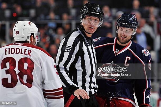 Forward Vernon Fiddler of the Phoenix Coyotes exchanges words with forward Rick Nash of the Columbus Blue Jackets as linesman Shane Heyer intervenes...