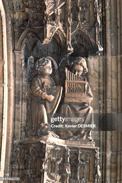 Anges musiciens jouant de la harpe et de l'orgue à main sur la voussure du portail septentrional. Ces anges sont sculptés sur le portail nord de la...