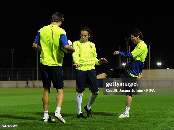 Lionel Messi of FC Barcelona jokes with his teammates Gabriel Milito and Gerard Pique during a training session on December 18, 2009 in Abu Dhabi,...