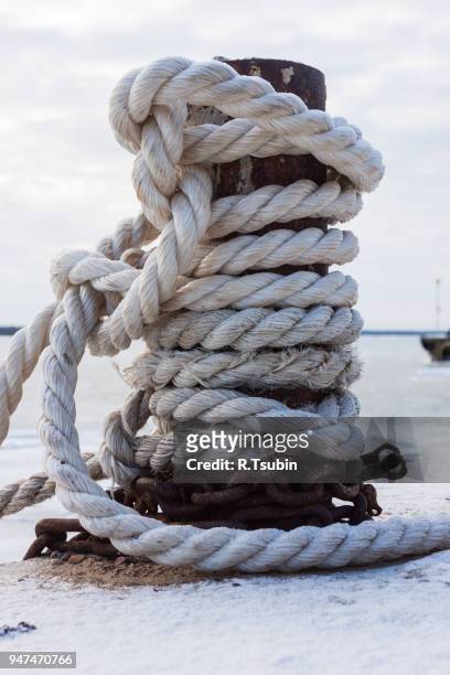 frozen ship cable under snow, old bollard at the pier in winter - moored stock pictures, royalty-free photos & images
