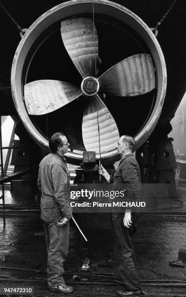 Installation d'une hélice sur un bateau dans un chantier naval.