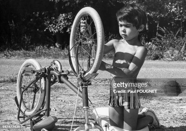 Enfant regonflant le pneu de son vélo.