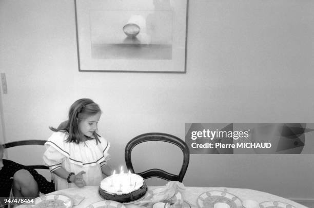 Petite fille soufflant les bougies pour son anniversaire.