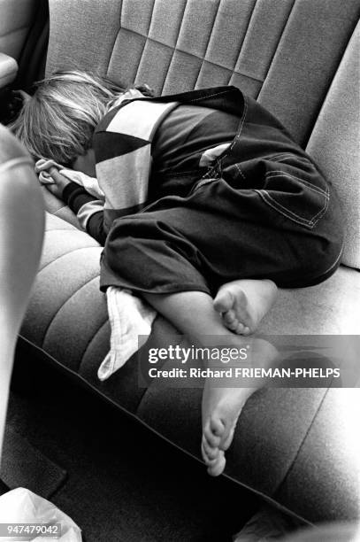 Enfant endormi sur la banquette arrière d'une voiture.