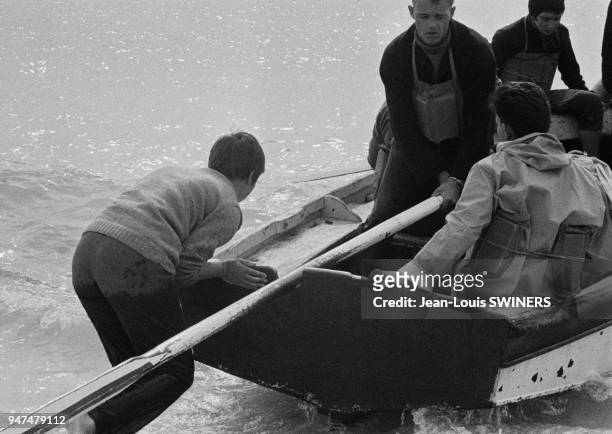Jeunes hommes sur une barque.