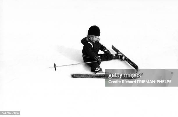 Enfant assis dans la neige après une chute de ski.