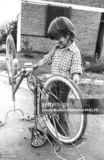 Enfant réparant son vélo.