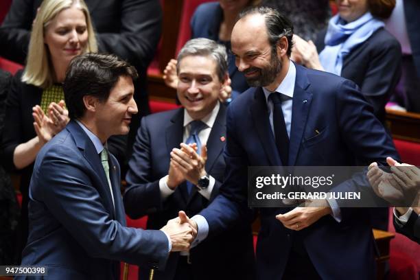 Canadian Prime Minister Justin Trudeau shakes hands with French Prime Minister Edouard Philippe prior to delivering a speech at the French National...