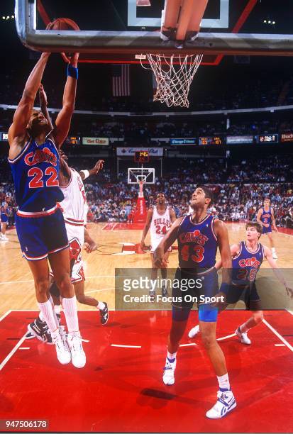 Larry Nance of the Cleveland Cavaliers goes up to grab a rebound against the Chicago Bulls during an NBA Basketball game circa 1990 at the Chicago...