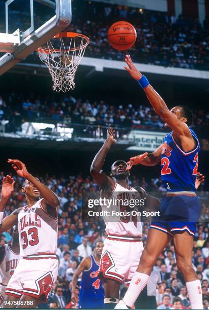 Larry Nance of the Cleveland Cavaliers goes in for a layup over Horace Grant of the Chicago Bulls during an NBA Basketball game circa 1990 at the...