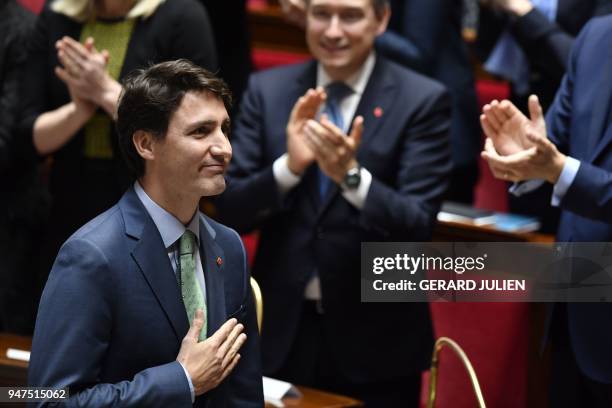 Canadian Prime Minister Justin Trudeau reacts as he is applauded after delivering a speech at the French National Assembly in Paris, on April 17 as...