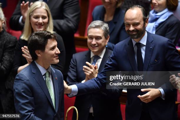 Canadian Prime Minister Justin Trudeau is applauded and greeted by French Prime Minister Edouard Philippe during a visit to the French National...