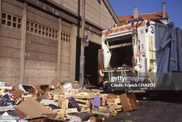 Camion poubelle et déchets après un marché, France.