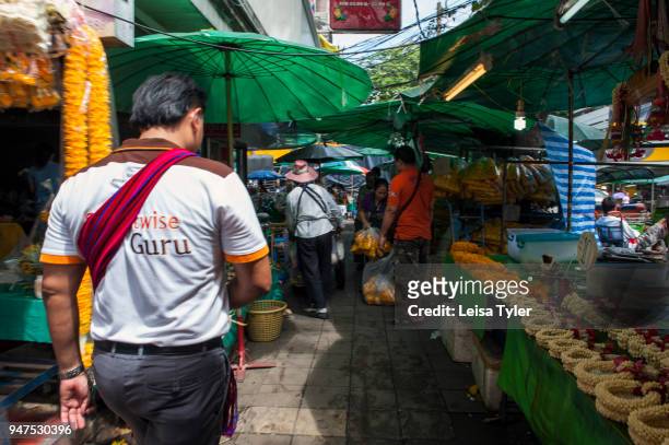 Guide from Anantara hotels taking toursits around Pak Khlong Talat, the main flower market in Bangkok.