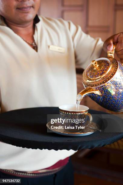 Teatime on the Anantara Dream A waiter pouring tea on the Anantara Dream, a 100-year old refurbished teak river boat, during a cruise on the Chao...