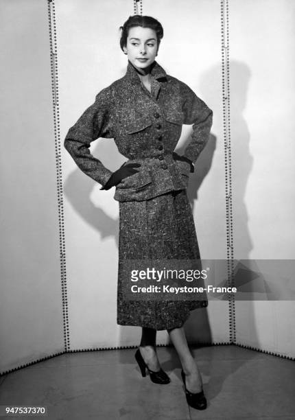 Tailleur en tweed très cintré fermé par des boutons de cuir, manches élargies. Création Madeleine Casalino, Paris le 15 février 1952.
