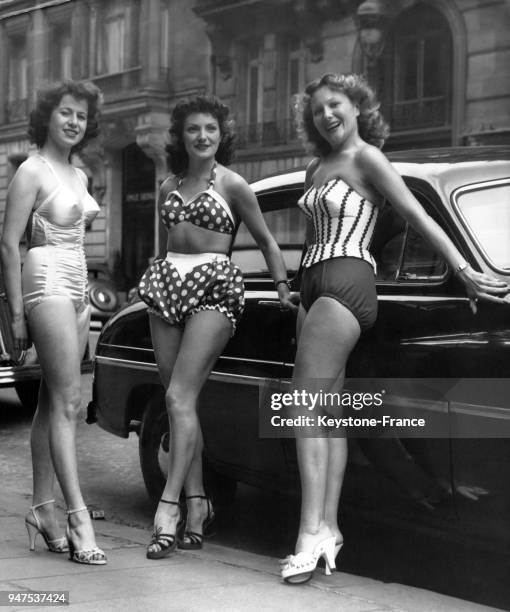 Trois jeunes femmes posent dans la rue, à l'occasion d'un gala de bienfaisance, en maillot de bain Chez Carrere , Paris le 22 mai 1951.