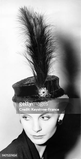 Chapeau de paille noir surmonté d'une longue plume noire, Londres le 5 novembre 1952.