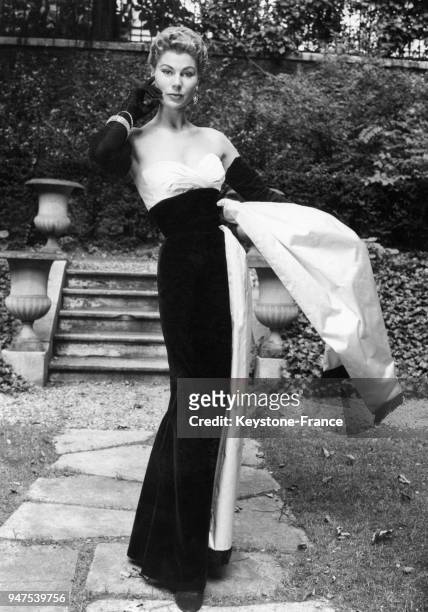 Robe du soir en velour noir, ceinture de satin blanc, pour l'hiver 1953-1954. Création Jacques Fath, Paris le 21 août 1953.