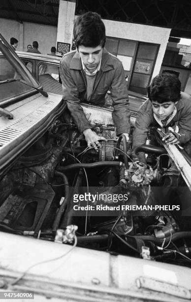 Adolescents en stage de mécanique dans un garage en France.