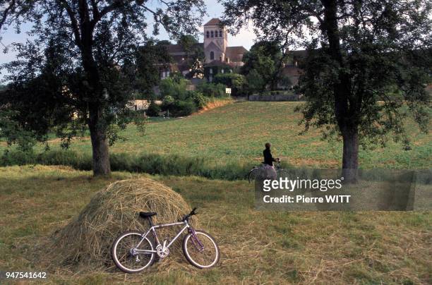 Vélo posé sur une motte de foin dans un champ en France.