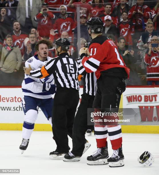 Linesman escourts Mikhail Sergachev of the Tampa Bay Lightning off the ice following a third period fight against Brian Boyle of the New Jersey...