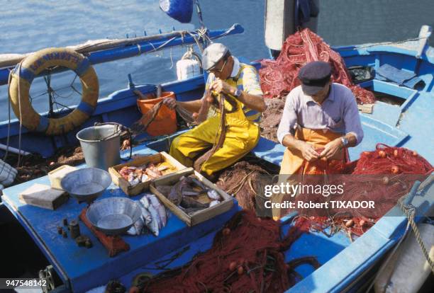 Pêcheurs réparant leurs filets sur l'île de Porquerolles, dans le Var, France.