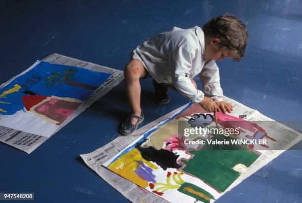 Enfant faisant de la peinture dans une école maternelle en France.