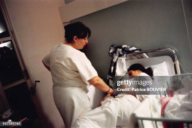 Sage femme avec une patiente dans la chambre d'une maternité en France.