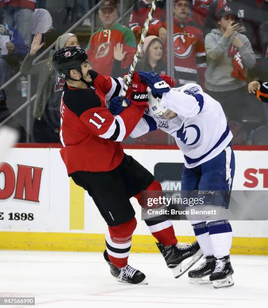 Brian Boyle of the New Jersey Devils hits Cory Conacher of the Tampa Bay Lightning in Game Three of the Eastern Conference First Round during the...