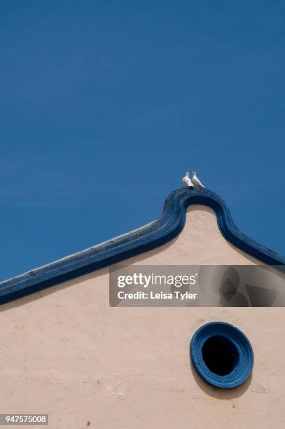 Two doves perch on top of a Dutch colonial building in Malacca , Malaysia. Malacca has World Heritage status for its architecture.