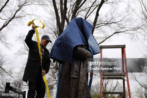 Parks Department worker fastens a statue of J. Marion Sims, a surgeon celebrated by many as the father of modern gynecology, before it is driven away...