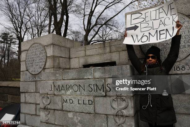 Woman stands beside the empty pedestal where a statue of J. Marion Sims, a surgeon celebrated by many as the father of modern gynecology, was taken...