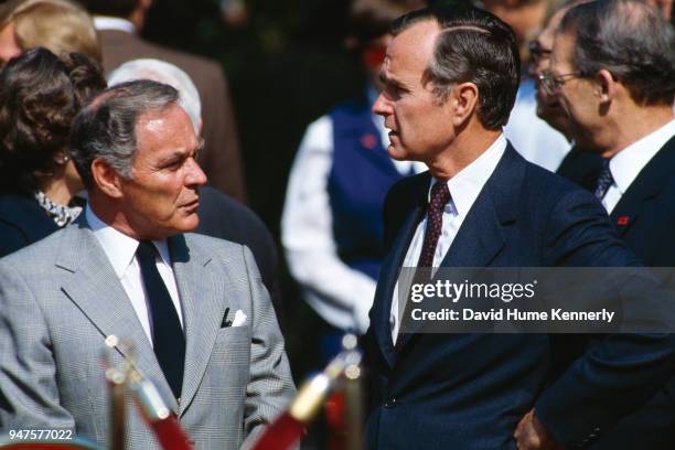 Vice President George HW Bush chats with Secretary of State Alexander Haig on the White House lawn during a welcoming ceremony for West Germany...