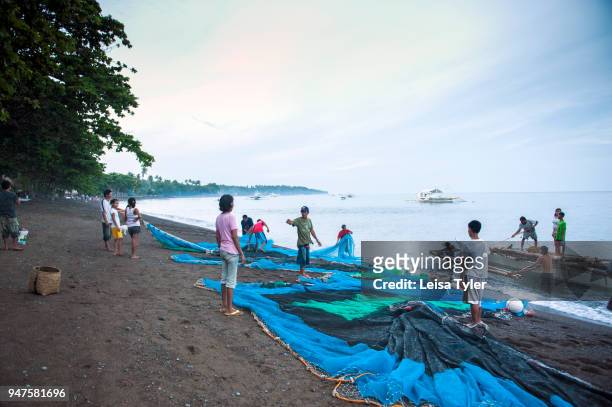 Villagers hauling in fishing nets on Dauin Beach, south of Dumaguete City in Negros Oriental.