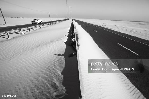 Les routes traversant le desert ont regulierment envahit par le sable deplace par le vent, il faut tres souvent passer degager les routes avec des...