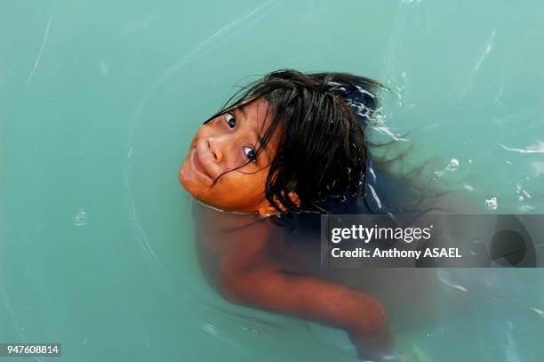 Kiribati, Tarawa Atoll, girl enjoying while swimming in green water.