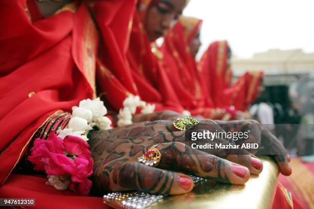 View of hands of a bride decorated with Hinna during mass wedding ceremony of Thirty couples held in Karachi on Saturday,July 23, 2011.