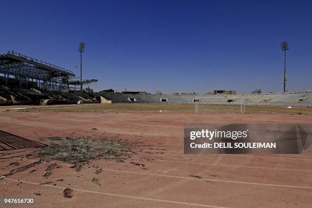 Shrapnel riddled track is seen during a football match between local teams al-Sadd and Rashid at a stadium in Raqa, the former Islamic State group's...