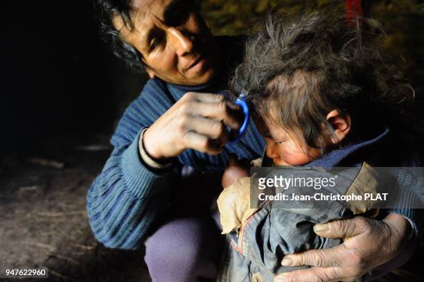 Rituel d' un homme Q'ero au village de Cocha Moco coupant les cheveux a un enfant, le 5 fevrier 2012, Perou.