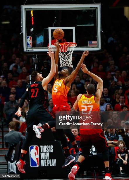 Jusuf Nurkic of the Portland Trail Blazers lays up the ball against Rudy Gobert and Derrick Evans of the Utah Jazz at Moda Center on April 11, 2018...