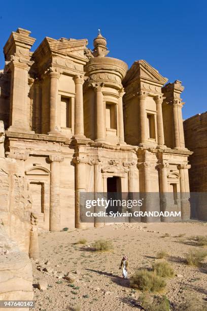 Young bedouins Ahmed Salem Albidul and Atef Salem Albidul climbing on top of the urne. The Deir, also called Monastery,has been carved in the rock on...