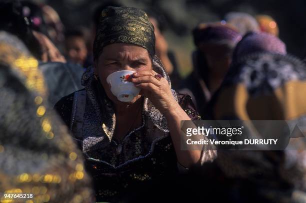 Femme buvant de la vodka lors d'un mariage dans le village tadjik de Farish, Ouzbékistan.