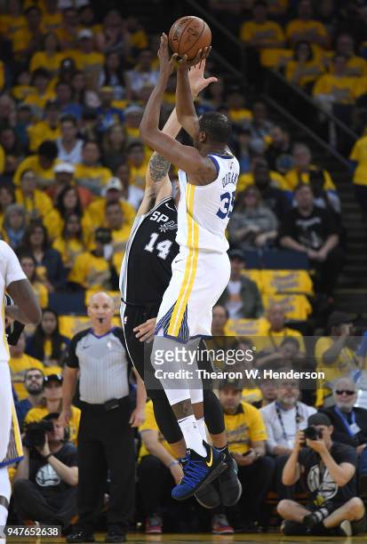 Kevin Durant of the Golden State Warriors shoots over Danny Green of the San Antonio Spurs in the second quarter during Game One of the first round...