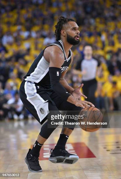 Patty Mills of the San Antonio Spurs dribbles the ball against the Golden State Warriors in the second quarter during Game One of the first round of...
