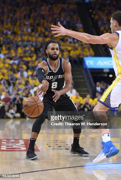 Patty Mills of the San Antonio Spurs passes the ball by Klay Thompson of the Golden State Warriors in the second quarter during Game One of the first...