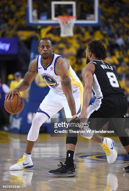 Andre Iguodala of the Golden State Warriors dribbles the ball while being guarded by Patty Mills of the San Antonio Spurs in the third quarter during...