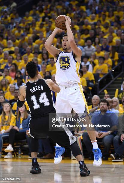 Klay Thompson of the Golden State Warriors shoots over Danny Green of the San Antonio Spurs in the third quarter during Game One of the first round...