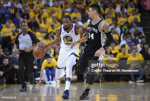 Kevin Durant of the Golden State Warriors dribbles the ball up court while being closely guarded by Danny Green of the San Antonio Spurs in the third...